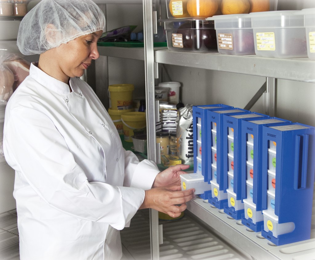 Employé de la restauration professionnelle rangeant ses plats témoins